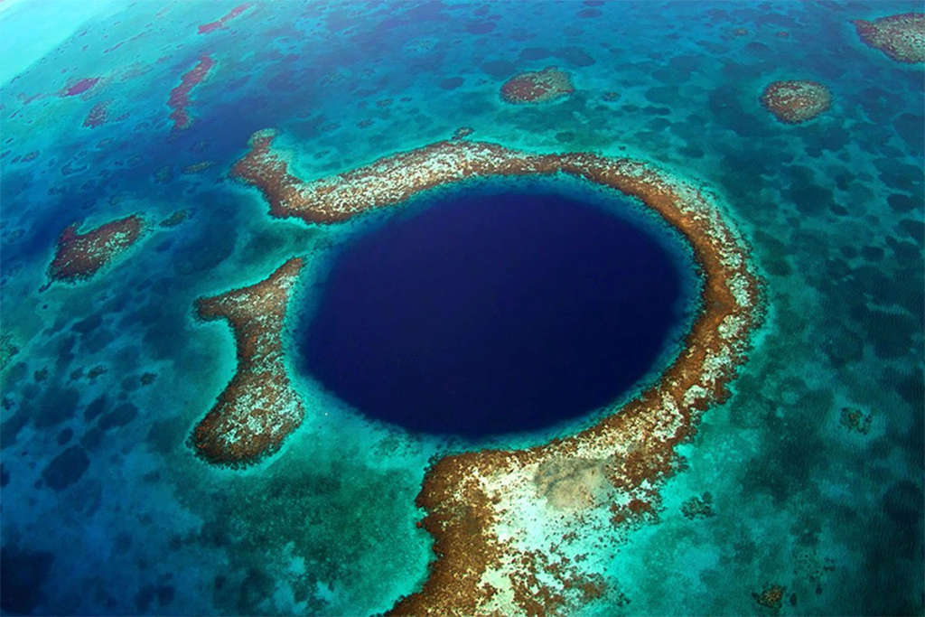 The Great Blue Hole, located off the coast of Belize, is one of the most striking and mysterious natural formations on the planet